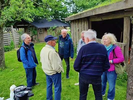 6 Personen stehen in einem Garten